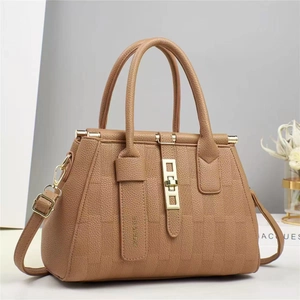 Dettaglio macro della borsa tote in pelle martellata marrone con elegante chiusura dorata