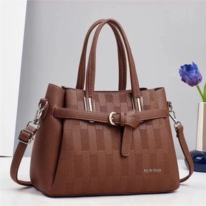 Détail d'un sac à main marron à motif litchi avec boucle argentée et décor floral