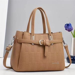 Gros plan d'un sac à main en cuir grainé kaki avec boucle argentée et décoration de tulipe