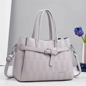 Détail du sac à main en cuir lavande avec gaufrage à damier et boucle en argent poli
