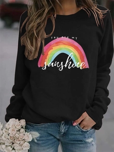 Close-up of rainbow print and 'You are my sunshine' text on black long sleeve sweatshirt