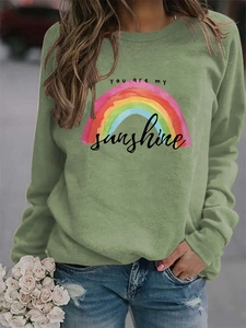Detail of sage green sweatshirt with rainbow graphics and you are my sunshine print
