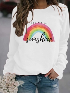 Detail of the rainbow print and You Are My Sunshine lettering on a white sweatshirt
