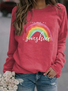 Detail of red crewneck sweatshirt with colorful rainbow and You Are My Sunshine print