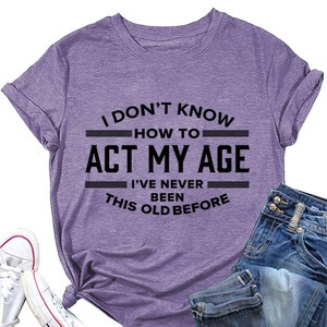 Paars katoenen T-shirt met tekst, denim korte broek en witte sneakers plat gelegd