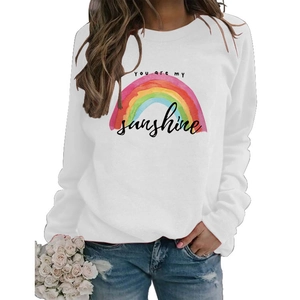 Detail of white crewneck sweatshirt featuring rainbow print and You are my sunshine text