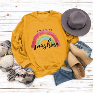 Flat lay of mustard yellow sweatshirt with You Are My Sunshine print and autumn accessories