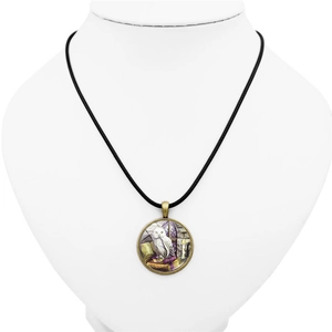 Détail du pendentif artistique chouette et livres sur cordon noir et cadre bronze