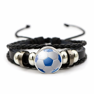 Detail of soccer themed layered leather bracelet with a blue football glass dome charm