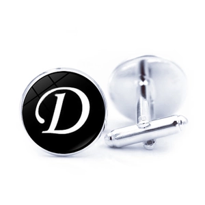 Macro view of silver cufflinks featuring letter D on black glass dome with T-bar closure