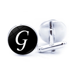 Detailed view of silver cufflinks with black letter G design and T-shaped swivel clasp