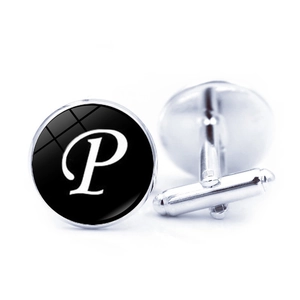 Detailed macro view of silver-toned metal cufflinks with black glass and white letter P
