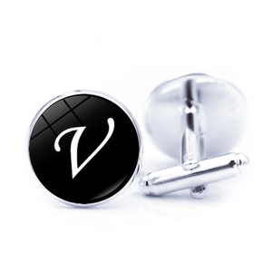 Detailed view of silver cufflinks featuring a round black dial with a white letter V