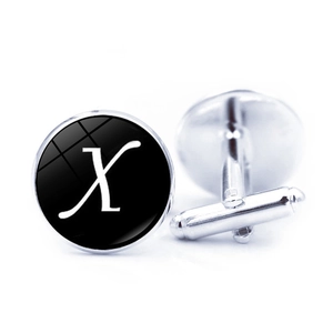 Close-up of silver men's cufflinks with black round glass insert featuring white letter X