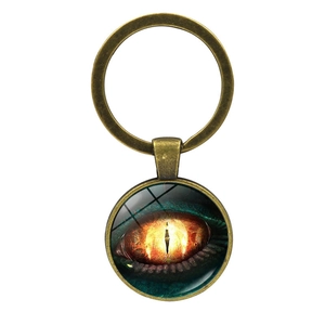 Detail view of a bronze metal keychain featuring a dragon eye glass dome pendant