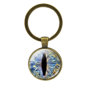 Detailed macro view of bronze dragon eye keychain featuring a vivid blue glass dome iris