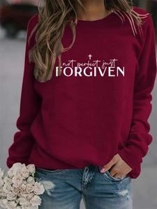 Detailed view of Not Perfect Just Forgiven printed text on burgundy crewneck sweatshirt