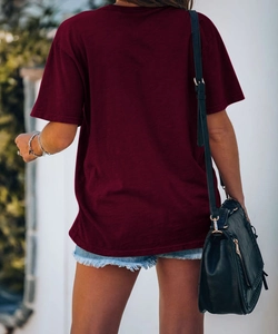 Vista posteriore di una t-shirt bordeaux girocollo casual abbinata a pantaloncini di jeans