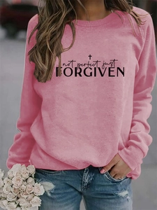 Detail of pink long sleeve sweatshirt featuring not perfect just forgiven text and cross