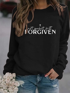 Close-up of Not Perfect Just Forgiven print and cross on black cotton sweatshirt