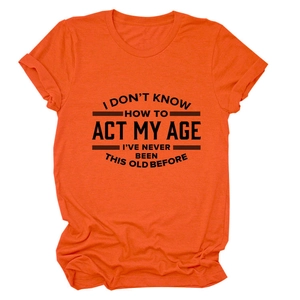 Detail van de creatieve belettering op een casual oranje katoenen T-shirt met ronde hals