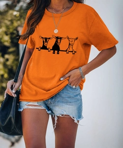 Dettaglio della T-shirt in cotone arancione vivace con simpatica grafica di capre