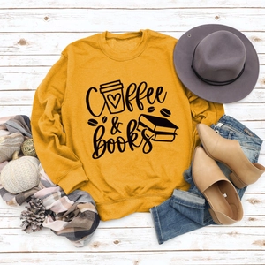 Mise à plat d'un sweat jaune moutarde avec motif Coffee & Books pour tenue d'automne