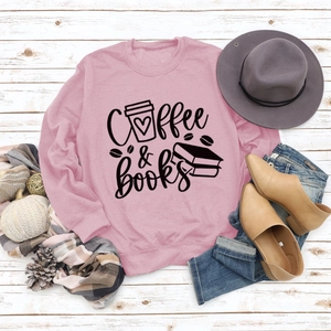 Vue à plat d'un sweat rose Coffee & Books avec accessoires d'automne sur bois