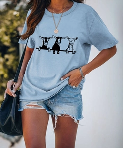 Dettaglio della stampa artistica con tre capre su una t-shirt girocollo azzurro chiaro