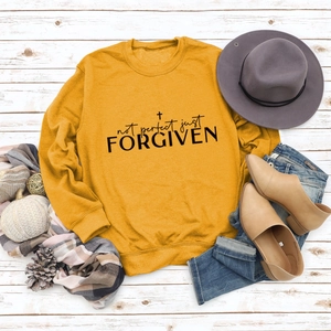 Flat lay of mustard yellow sweatshirt with seasonal autumn accessories on white wood