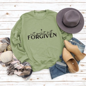 Flat lay of green long sleeve sweatshirt with Not Perfect Just Forgiven cross print