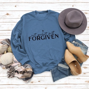 Flat lay of foggy blue sweatshirt with Not Perfect Just Forgiven text and cross detail