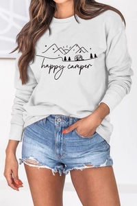 Detail des Happy Camper Aufdrucks auf einem weißen Sweatshirt mit Outdoor-Motiven