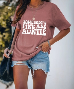 Détail de l'imprimé SOMEBODY'S FINE ASS AUNTIE blanc sur un T-shirt rose à col rond décontracté