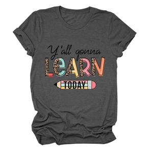 Détail du t-shirt gris foncé avec texte Y'all gonna learn today et crayons colorés