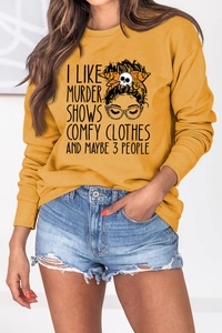 Close-up of mustard yellow sweatshirt with ribbed cuffs and unique graphic print