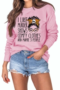 Detail of pink crewneck sweatshirt featuring cartoon graphic and humorous quote text