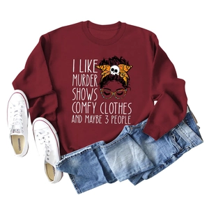 Detail view of burgundy crewneck sweatshirt with cartoon graphic and casual lifestyle props