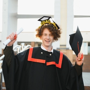Close-up of black graduation headband featuring a mini mortarboard with golden GRAD and tassel
