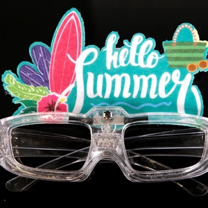 Macro shot of tropical party glasses with Hello Summer surfing board and LED light module