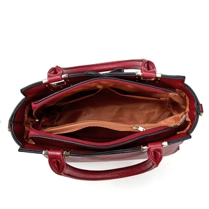 Detail view of the spacious inner compartments and interior lining of the burgundy handbag
