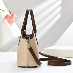 Detail view of contrast color crossbody bag with lychee texture and silver hardware