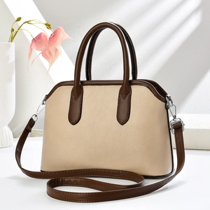 Detailed view of beige lychee texture shell bag with coffee color trim and silver hooks