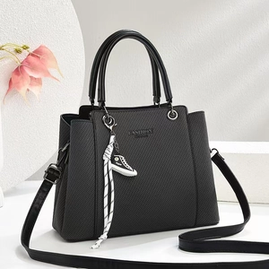 Chic black textured tote bag for women featuring a trapezoid shape and fashion charm