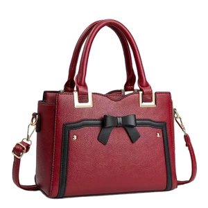 Deep red pebbled leather tote bag with black bow and adjustable shoulder strap