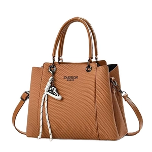 Brown textured leather handbag for women featuring a Fashion Queen print and sneaker charm