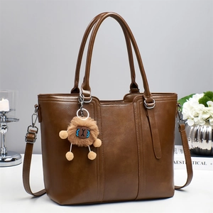 Detailed view of deep brown tote bag with premium leather texture and lion charm