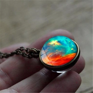 Macro detail of a galaxy nebula glass ball pendant necklace with vintage bronze finish