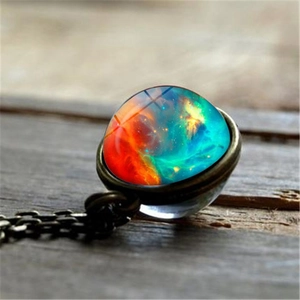 Vintage galaxy nebula glass ball pendant necklace on a rustic wooden surface