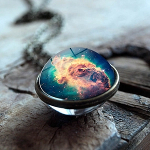 Detailed close-up of galaxy nebula glass ball pendant with vintage metal base
